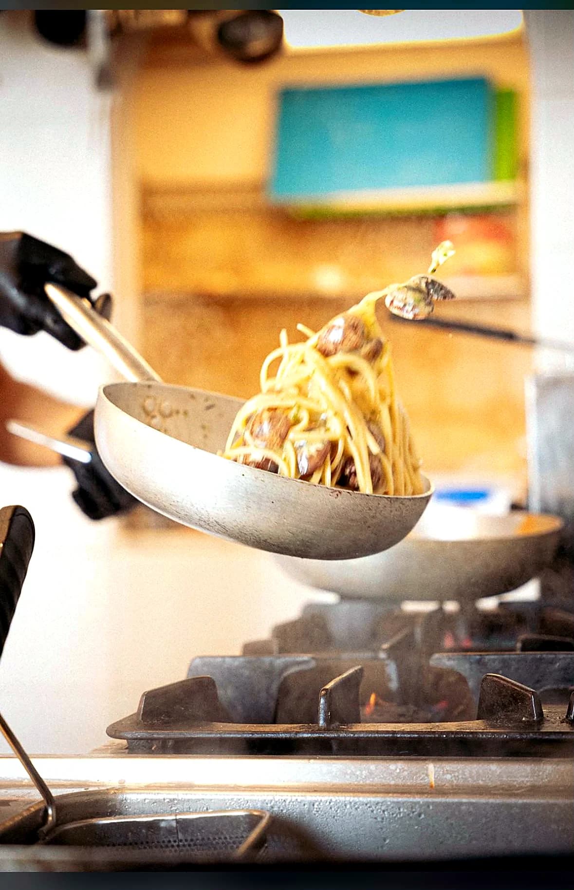 Pasta al volo sul fuoco nella cucina di Da Mimmo